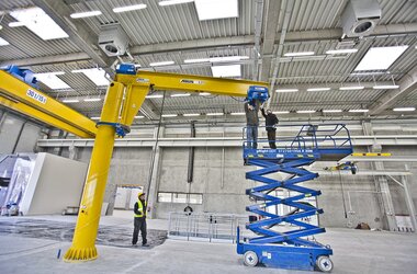 Montage van een trolley op een vrijstaande zwenkkraan in een productiehal van het bedrijf Rolls-Royce in Polen